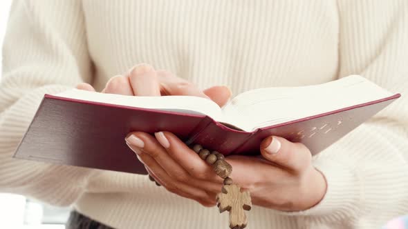 Close Up of a Woman Holding Bible Book and Wooden Beads alt