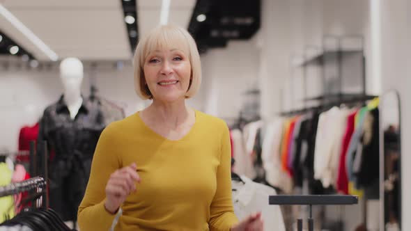 Cheerful Active Mature Professional Female Saleswoman Dancing in Clothing Store Advertises New alt