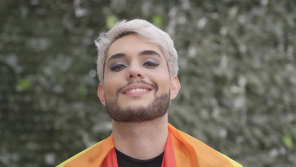 Young Transgender Smiling on Camera Wearing LGBT Rainbow Flag