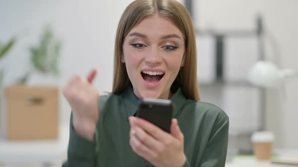 Young Woman Celebrating on Smartphone alt