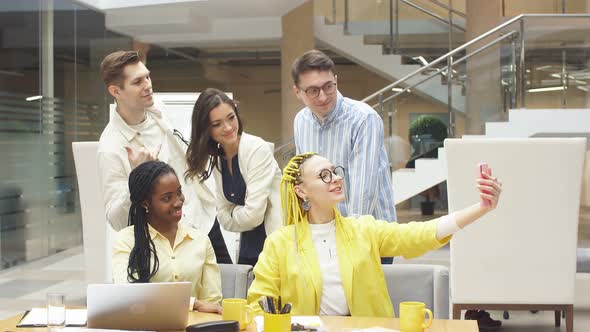 Happy Cheerful Colleagues Making Selfie with the Sell Phone. Office Interior alt