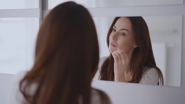 Woman Looking at Mirror at Home alt