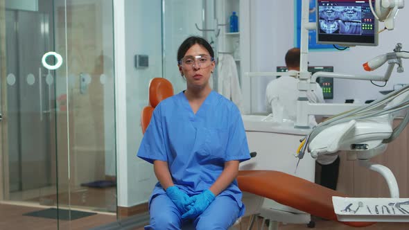 Dental Assistant Looking at Camera Speaking with Patients alt