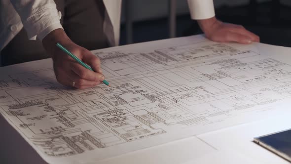 Close Up of Engineer's Hands Making Notes on Control Electronics Scheme alt