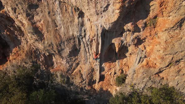 Aerial Point of View From Drone of Strong Muscular Man Climbs Challenging Rock Climbing Route alt