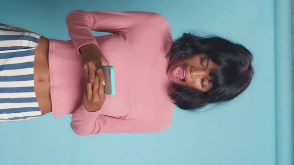 Young Overjoyed Asian Woman with Phone Have Fun and Start Dancing in Studio alt