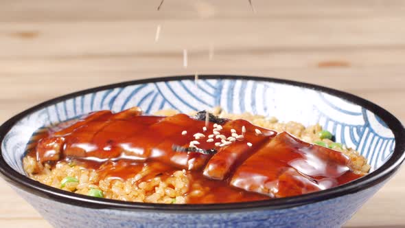 Sesame and seaweed dropping on top of Unagi fish rice - Japanese food cuisine alt