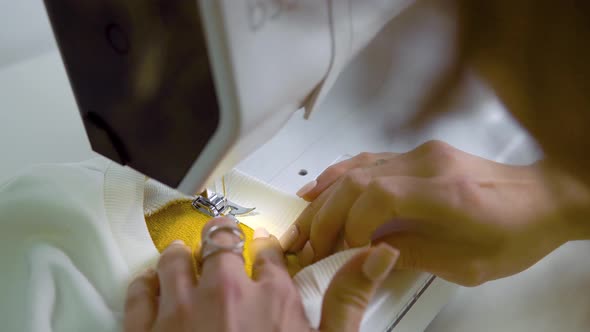The Woman Works with a Piece of Cloth on the Sewing Machine alt