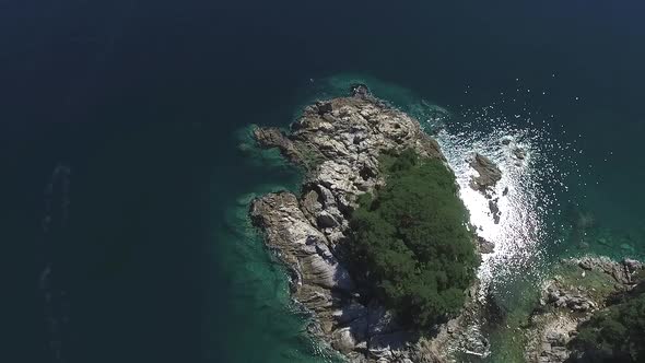 Aerial Over Small Island Covered with Tropical Rainforest Stone Shore Belt Around Woods alt