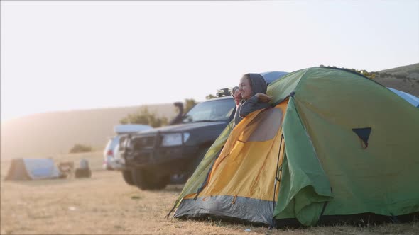 Young Woman Wakes Up and Comes Out From Tourist Tent and Stretches alt