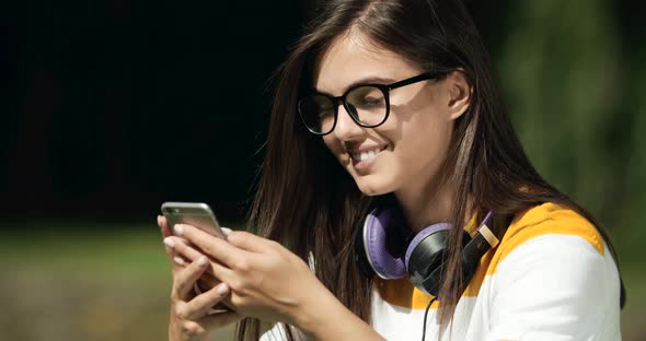 Woman Browsing Smartphone in Park