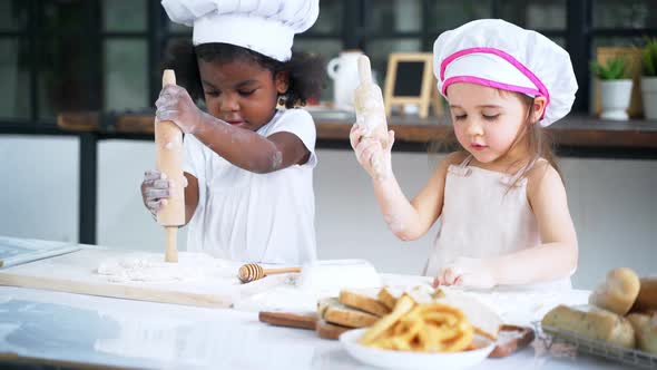 Little Girl Baking Cookies in the Kitchen While Copying and Peeking Kid in the Class at School alt