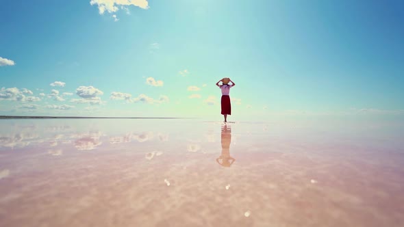 Rear View Woman in Straw Hat Enjoying Beautiful Nature at Pink Salt Lake