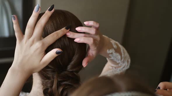 Bridesmaid Inserts a Veil Into the Bride's Hair Before the Wedding alt
