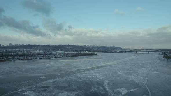 A River Covered with Ice in Winter with a City on the Bank