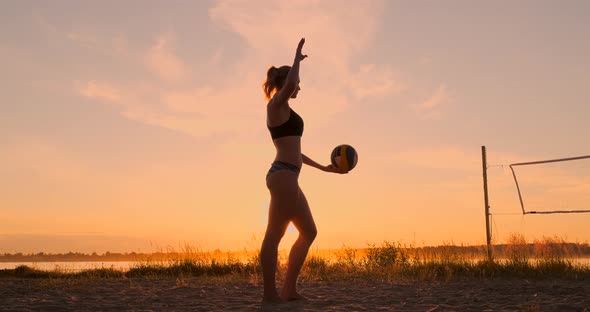 Athletic Girl Playing Beach Volleyball Jumps in the Air and Strikes the Ball Over the Net on a alt