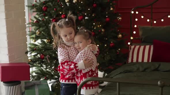 Affectionate Girl Patting Her Sister at Xmas.