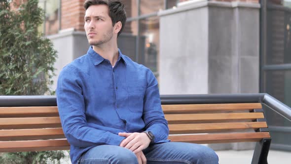 Waiting Young Man Watching Time on Watch Sitting on Bench alt