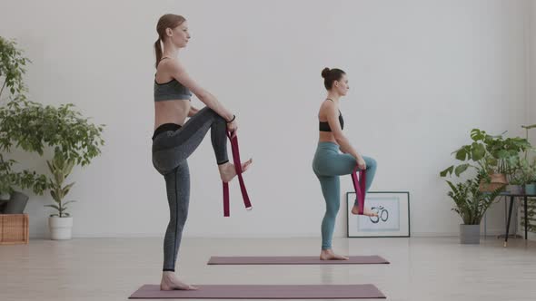 Two Young Women Using Yogic Belts during Training alt