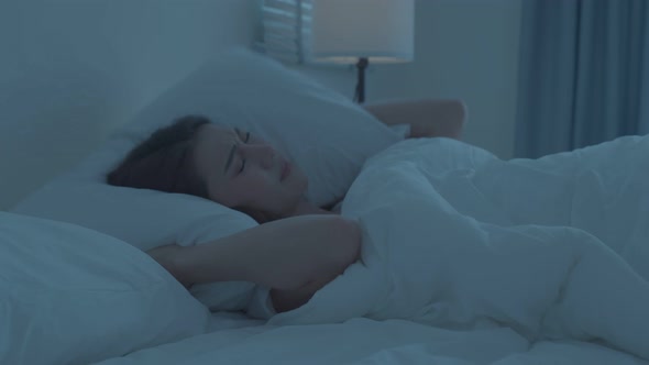 Asian beautiful frustrated girl in pajamas sleep on bed in dark night. alt