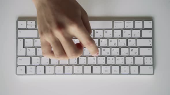 Male Hands Slowly Learning to Type on a White Computer Keyboard