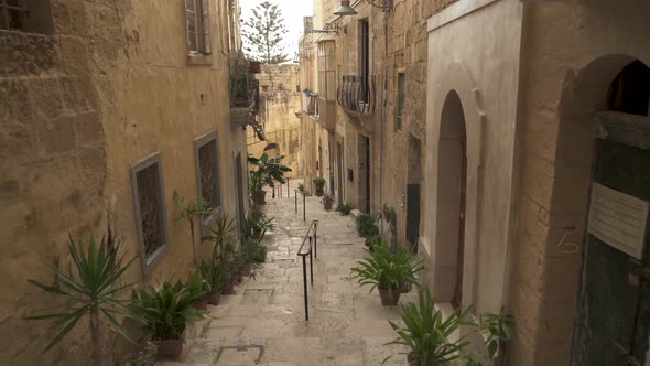 Climbing Down Stairs Made From Stone in a Narrow Street in Birgu, Malta