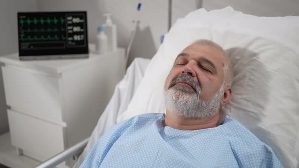 The Face of an Elderly Man Lying on a Bed in a Hospital Unconscious Asleep alt
