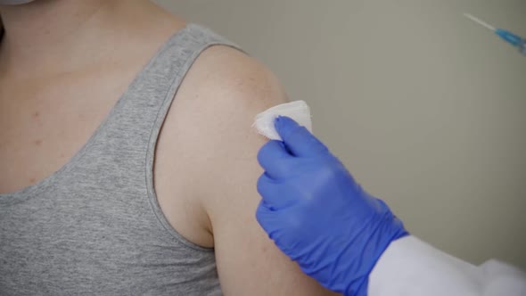 A Nurse Gives a Woman Patient a Mandatory Flu Shot