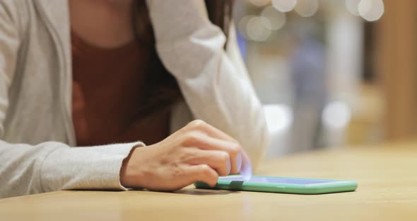 Woman working on smart phone in cafe alt