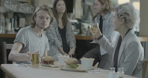 Men and women enjoying food and talking in pub