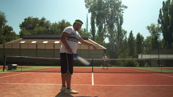 Anonymous Men Playing Tennis on Court in Summer