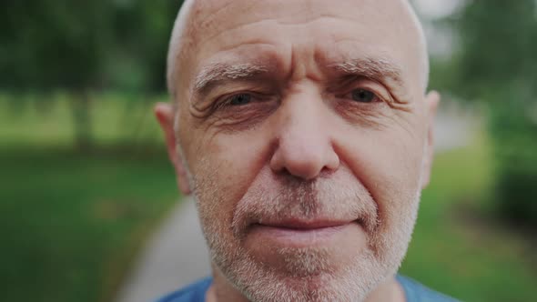 Close Up Portrait of Confident Enjoying Successful Old Man with Piercing Gaze alt