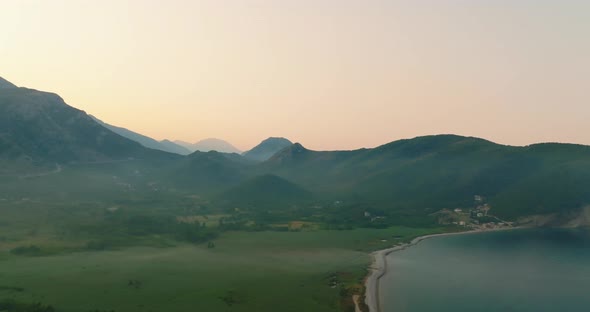 aerial view during sunrise on mountain with clouds and beach alt