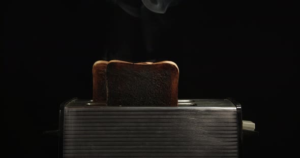 Burnt toast popping up in a toaster