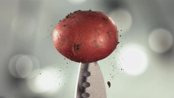 Fresh Red Potato Falling Down with Soil on Knife Stuck alt