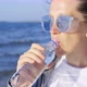 A Girl Drinks Clean Fresh Water After Jogging on the Beach of Lake Baikal - VideoHive Item for Sale