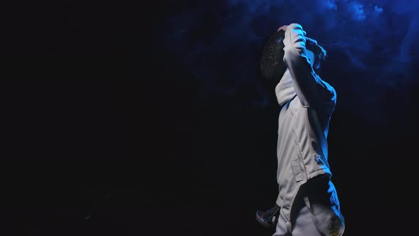 Side View of a Young Guy, a Fencing Athlete Who Puts on a Mask and Gets Into a Fighting Position alt