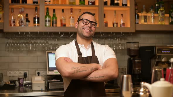 portrait of a confident smiling bartender at the bar in a restaurant alt