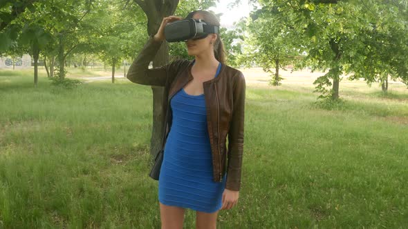 Sexy Cheerful Girl Uses A Virtual Reality Helmet In The Park