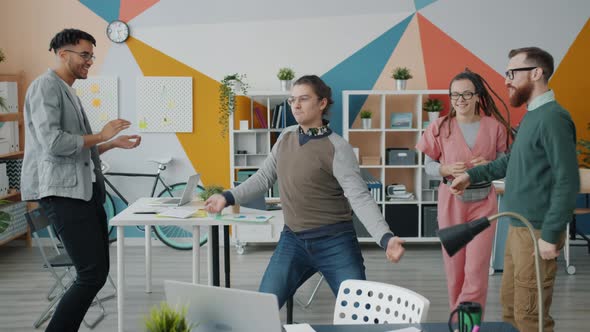 Slow Motion of Excited Young People Colleagues Dancing in Workplace Having Fun Laughing alt