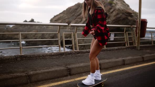 Young Pretty Beautiful Brunette Hipster Woman in Plaid Coat Having Fun Riding Skateboard Longboard alt