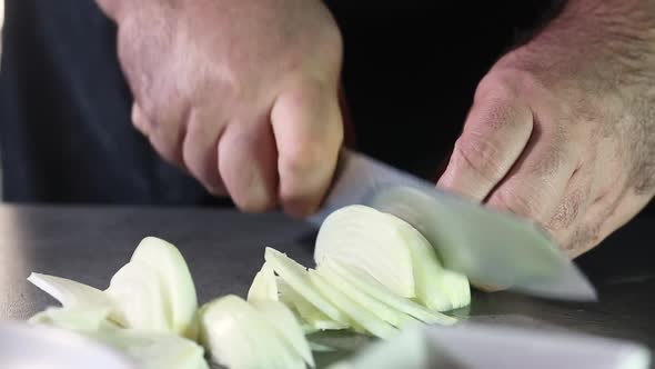 Professional chef cuts the onion into thin slices