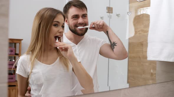 Young Caucasian Guy Kissing Girlfriend While Brushing Teeth Stock Footage