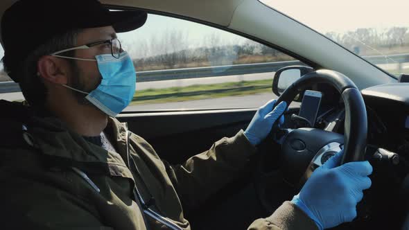 Man in Medical Mask and Gloves Drives a Car