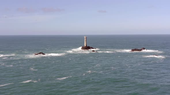 Isolated Lighthouse at Sea on a Rock During the Summer alt
