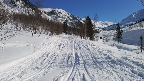 Riding Snowmobiles in Mountains in Winter