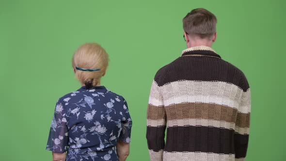 Grandmother and Grandson Turning Then Smiling with Arms Crossed Together alt