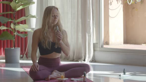 Beautiful Blond Caucasian Young Woman is Making Meditation with Sage Smudge Sticks