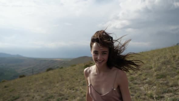 Happy Girl Runs Through the Mountainous Terrain, Spins and Enjoys Herself
