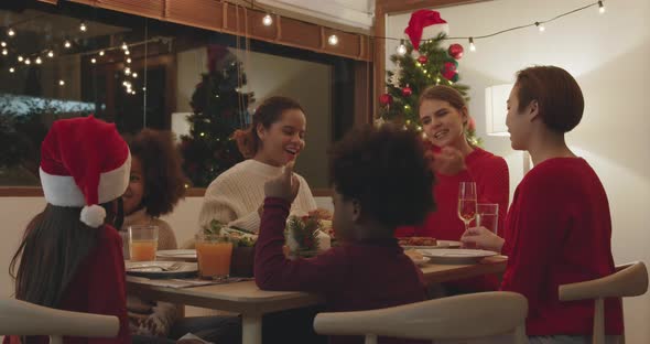 Group of children and mothers having dinner celebrating Christmas